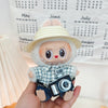 Blue plaid shirt + cuffed blue jeans + off-white flat-brim straw hat + black camera